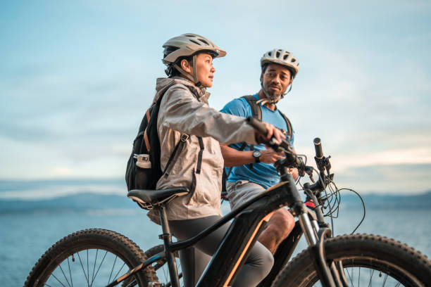 istock Active Diverse Couple with Electric Bikes Enjoying Seaside Sunrise 2195462119