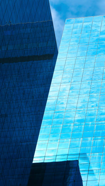 istock Intersecting Reflections  A dynamic composition of skyscraper glass facades, with bold angles and contrasting shades of blue reflecting the sky and light 2195464000