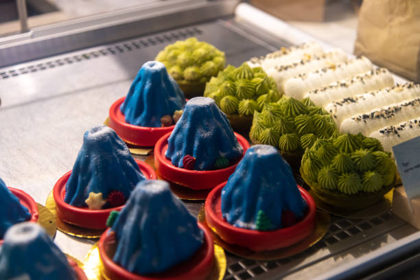Colorful desserts resembling mountains displayed in a bakery showcasing unique pastry designs in an urban setting