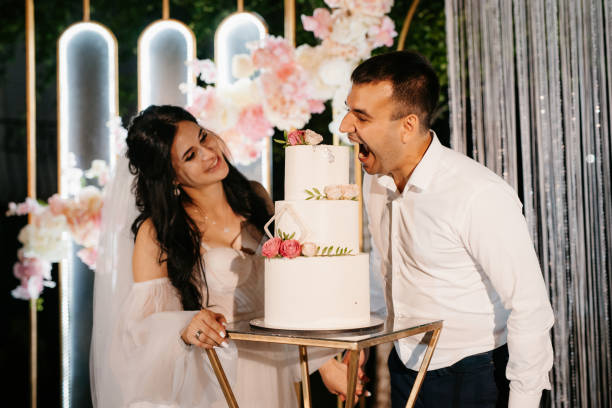 istock newlyweds happily cut the wedding cake on the wedding arch 2195465465