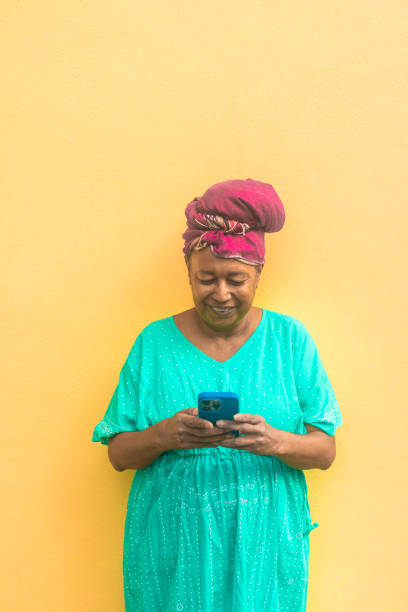 istock African senior woman using mobile phone while wearing traditional ethnic clothes - Technology, ethnicity and mature people concept - Vertical photo 2195466638