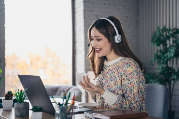 istock Woman enjoying a virtual interaction while having coffee at home, surrounded by a cozy indoor setting and modern amenities. 2195466680