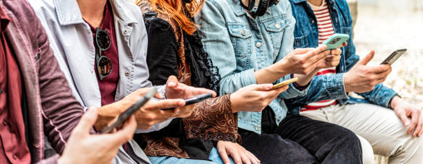 istock Group of young people using smart mobile phone device outside - Trendy technology concept with guys and girls playing video games app on smartphone 2195468380