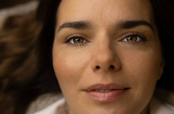 The make-up artist does eyelash lamination. She paints eyelashes, shapes eyebrows, curls eyelashes, applies dye and certain