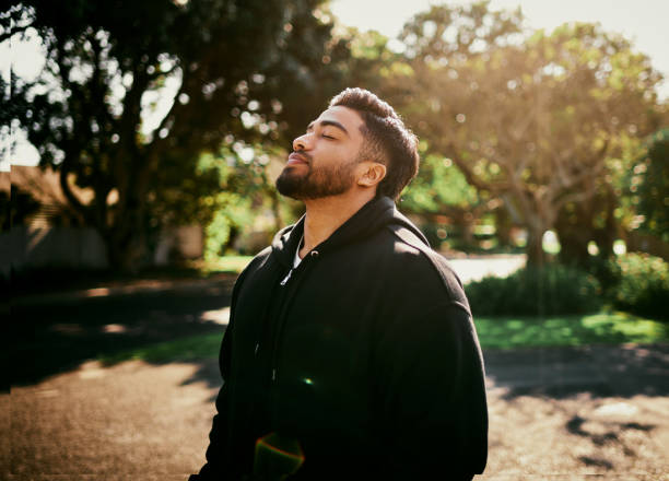 istock Man in Hooded Jacket Breathing Fresh Air in Park 2195471621