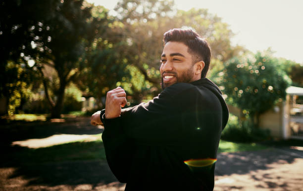 istock Cheerful Man Stretching Arms During Warmup in Serene Park 2195471624