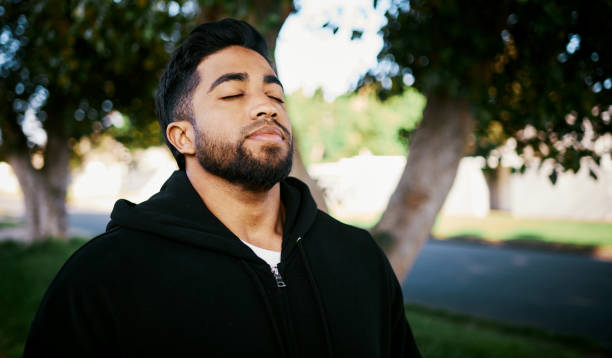istock Man Enjoying Fresh Air with Closed Eyes in a Park 2195471626
