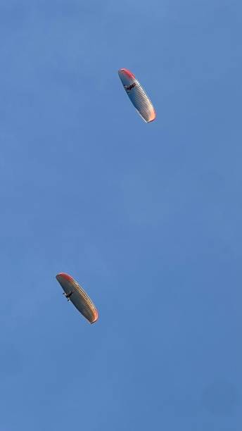 istock Two paraglider flying in the blue sky with copy space. 2195475001