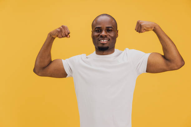 istock Strong African American Man Showing Muscles on Yellow Background 2195477866