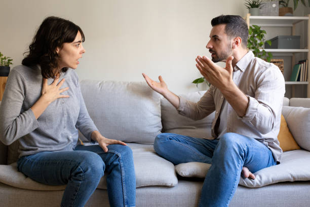 istock Young couple arguing while sitting on sofa at home 2195478239