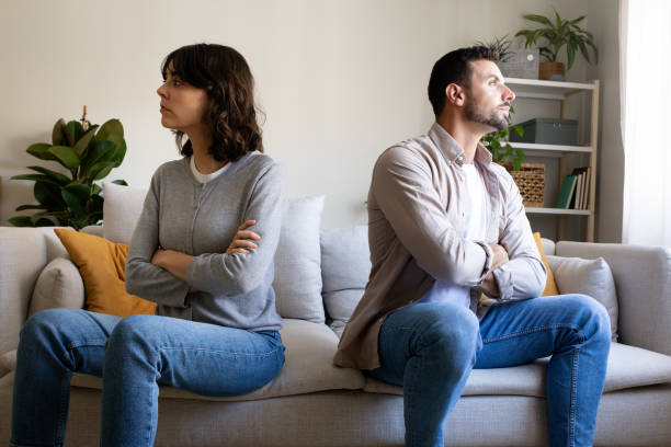 istock Stubborn couple sitting back to back on sofa after quarrel at home, having relationship problems 2195478269