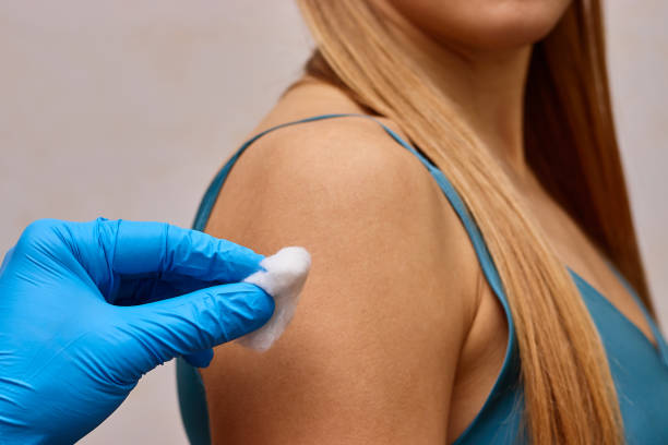 istock Doctor disinfects patient's hand before injection. 2195478752
