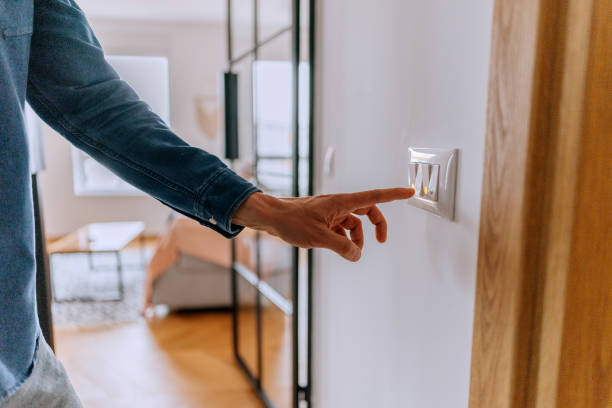 istock Unrecognisable man turning on or off light switch at home 2195479301