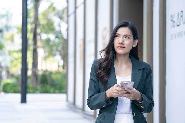 istock Senior asian businesswoman working outdoors using phone casual setting professional viewpoint focus on productivity 2195482137