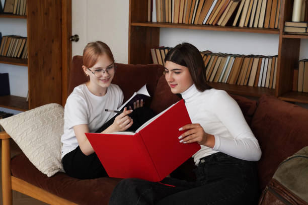 istock Students Studying in a Modern Library. two teenage girls Thinking and Homework Solving, School students  Work on a School Research Project 2195482256
