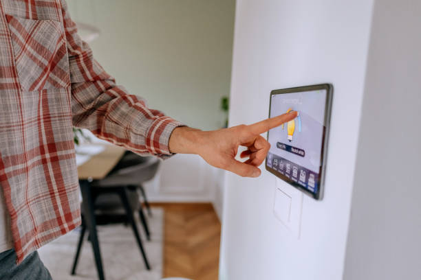 istock Close up shot of an unrecognisable man controlling lights on smart device attached on wall 2195482667