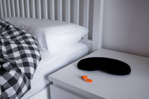 istock Cozy bedroom with sleep mask, earplugs, and checkered bedding for a restful night 2195482826