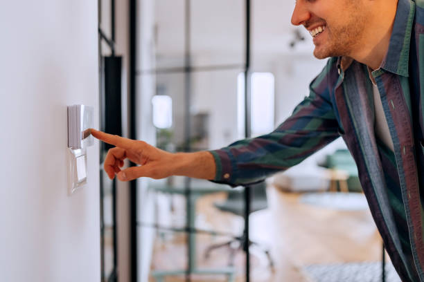 istock Young casually clothed man setting up temperature at home with a device on the wall 2195487896