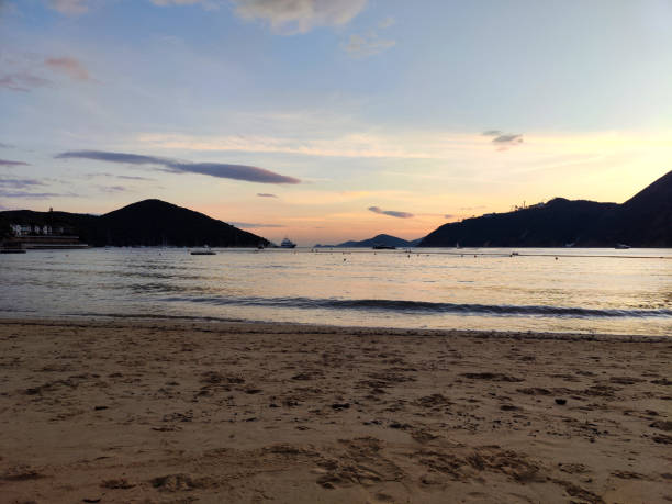 Dusk on Deep Water Bay beach. The bay is located on the southern shore of Hong Kong Island in Hong Kong. The bay is surrounded by Shouson Hill, Brick Hill, Violet Hill and Middle Island.