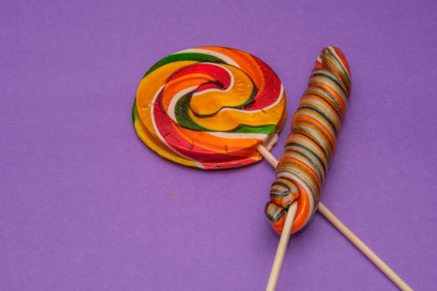 Colorful lollipops on a vibrant purple background. This playful image captures the essence of fun and sweetness, featuring whimsical candy and joy.