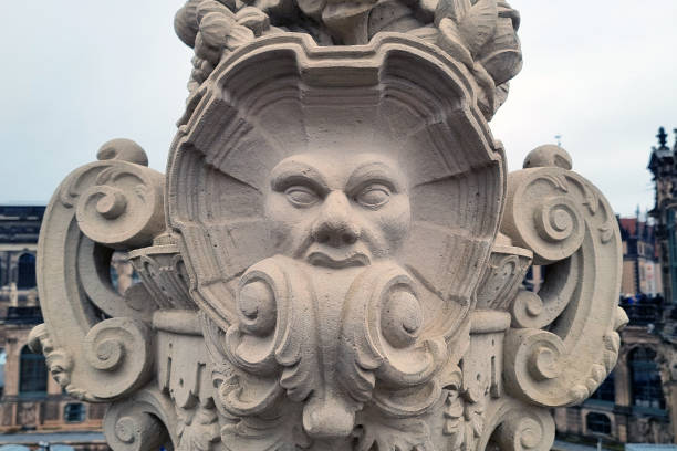 Dresden, Germany, December 8, 2024: Intricately carved stone sculpture featuring a stylized face motif, part of historic architecture. the detailed craftsmanship and swirling designs highlight classical art influences within an ancient building complex.