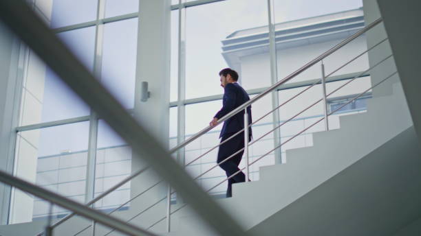 istock Successful ceo walking downstairs modern building. Confident businessman going 2195492754