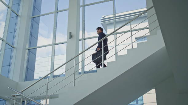 istock Businessman hurrying work meeting walking down staircase office environment. 2195493165