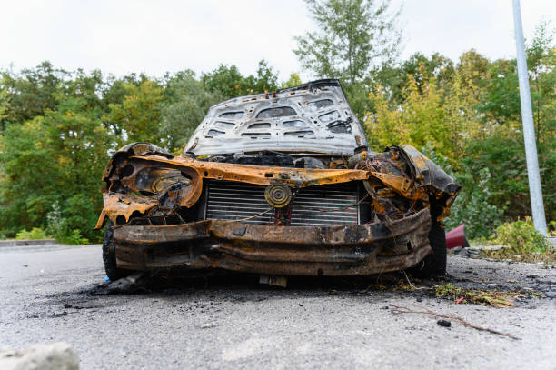 istock Burned car wreck abandoned on roadside in nature 2195493253