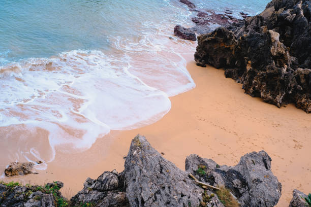 istock A rocky beach with a white ocean wave crashing against the rocks. 2195493578