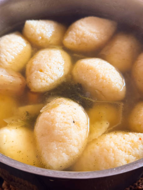 Homemade beef broth soup with semolina dumplings, root vegetables and bone marrow broth