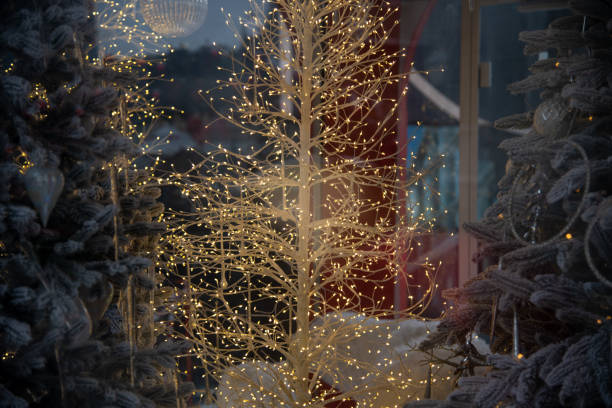 istock Illuminated white tree sparkles amidst festive decorations in a winter wonderland setting with holiday charm 2195496111