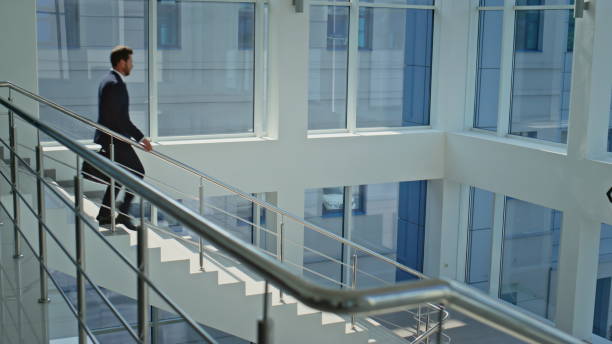 istock Motivated manager walking downstairs modern sunlit office. Bearded businessman 2195496500