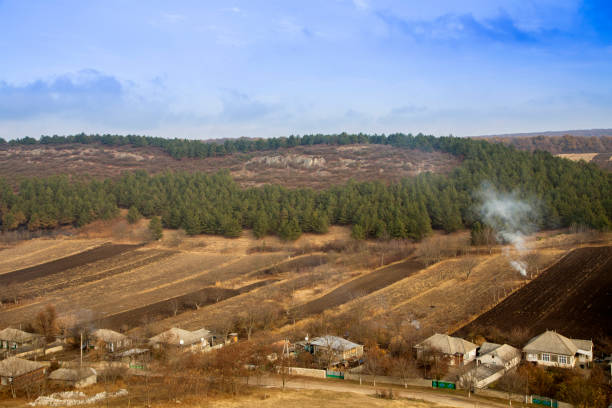 Rocky hills and houses with fields against a beautiful blue sky