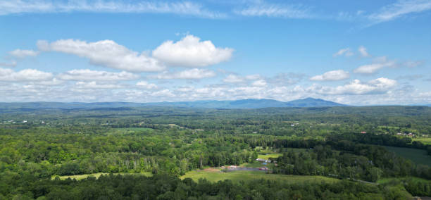 istock view of catskill mountains at sunset (wide angle aerial mountain vista in catskills hudson valley slide mountain wilderness hiking area) dramatic huge puffy clouds sky cloud formation farm rural area 2195498924