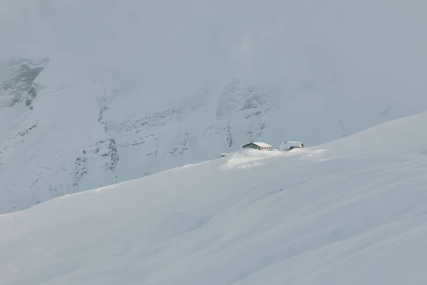 Single house in the Alps surrounded by deep snow, creating a peaceful winter scene