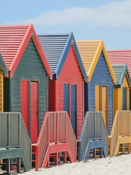 istock Colorful wooden beach huts lining sandy shore, contrasting azure sky, representing iconic seaside landscape of muizenberg near cape town, south africa 2195500238