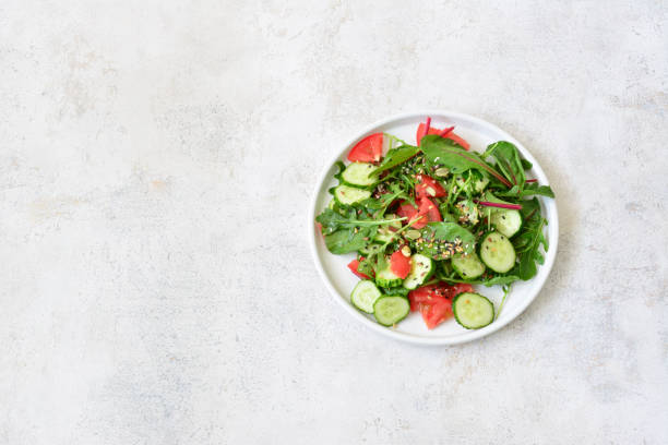 istock Fresh Green Salad with cucumber, tomato, greenery and seeds copy space 2195500944