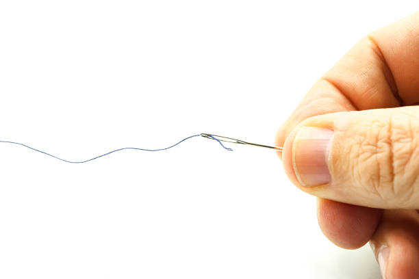 istock Hand holding a needle with thread, sewing, clothing alterations. 2195503244