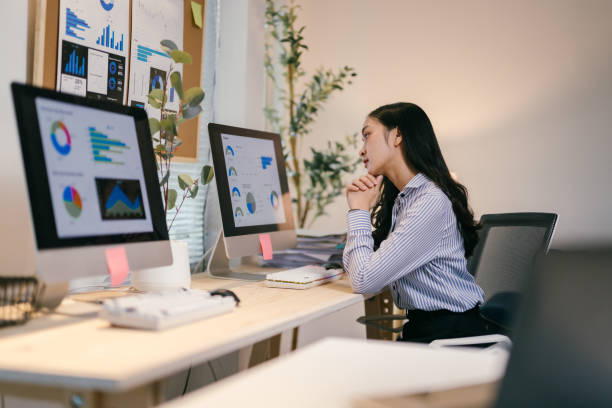 istock Professional female executive reviewing financial data across multiple monitors, tracking market performance with concentrated business analysis 2195503632