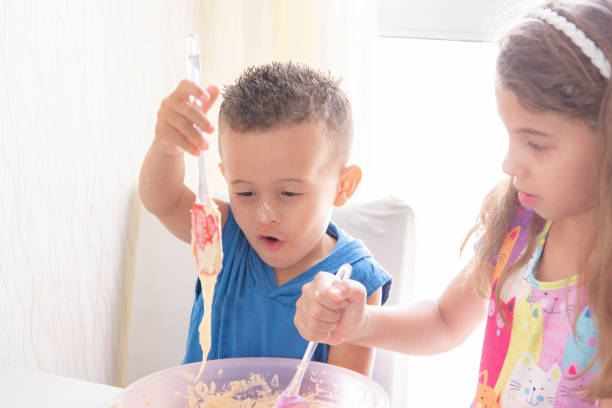brothers kids mixing recipe at table