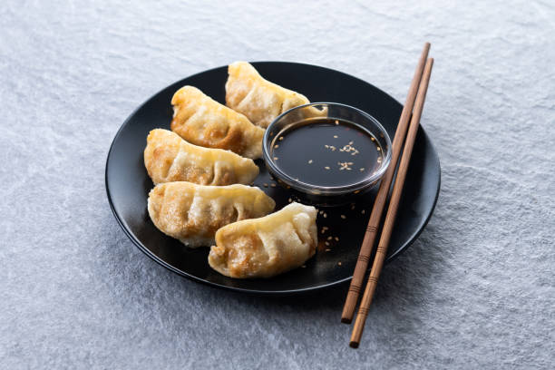 istock Fried dumplings gyoza with soy sauce on grey stone background 2195507835