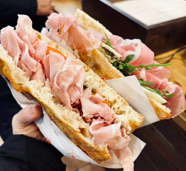 Italian food. Focaccia sandwiches with crispy crust and prosciutto. Street food. Close-up.