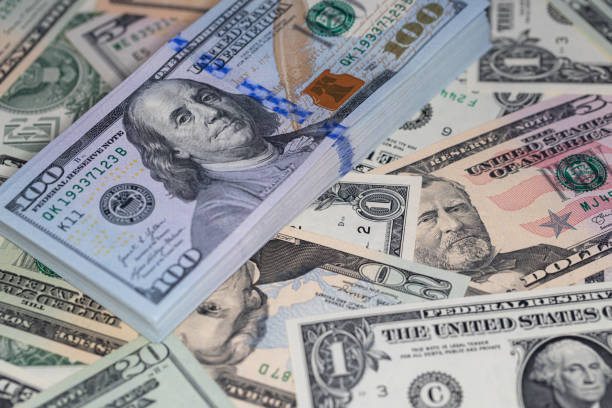 pile of US 100 dollar banknotes on spread dollar banknotes for design purpose