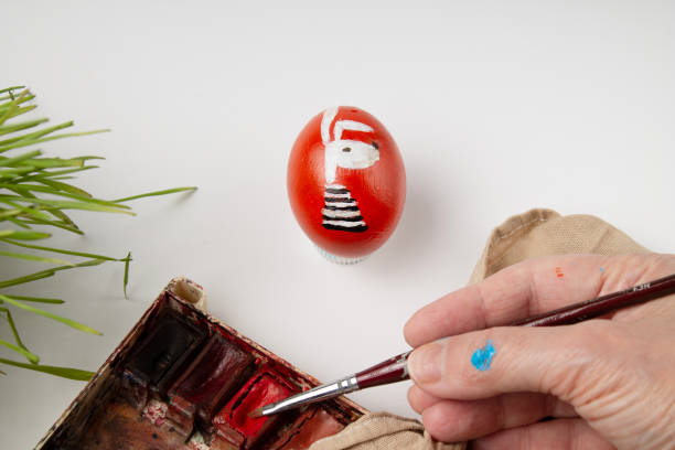 artist draws a watercolor white rabbit on a red egg, space for text on a white background