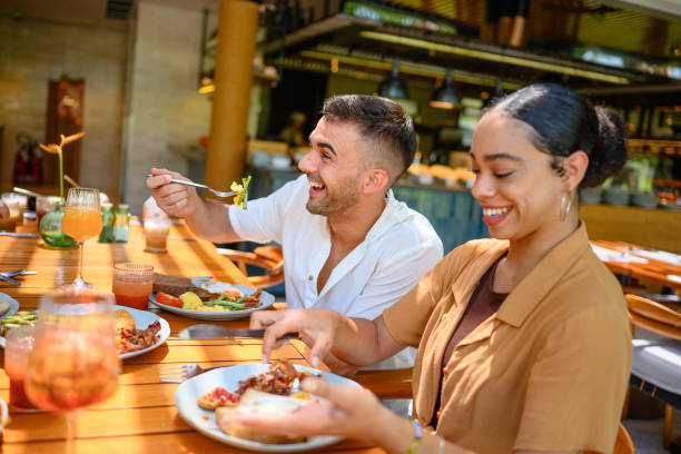 istock Joyful Diverse Couple Enjoying Breakfast in Cozy Cafe 2195526154