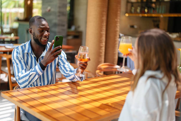 istock Joyful Couple Taking Photos in Tropical Bar 2195526349