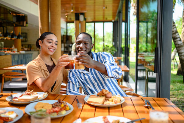 istock Cheerful Multiracial Couple Enjoying Breakfast in Cozy Cafe 2195526366