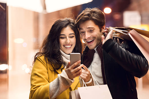 Couple Enjoying Their Shopping Experience While Checking Their Phone in the Evening
