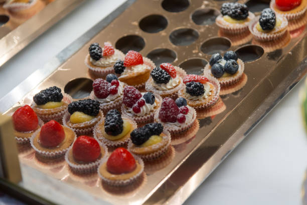 istock Delicious assortment of fruit-topped pastries displayed at an elegant dessert table during a festive event 2195531033