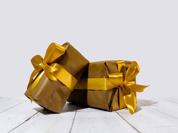 istock A collection of  gift wrapped presents in boxes with a gold ribbon bows. 2195531071